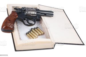 A gun hidden inside a book isolated on white background