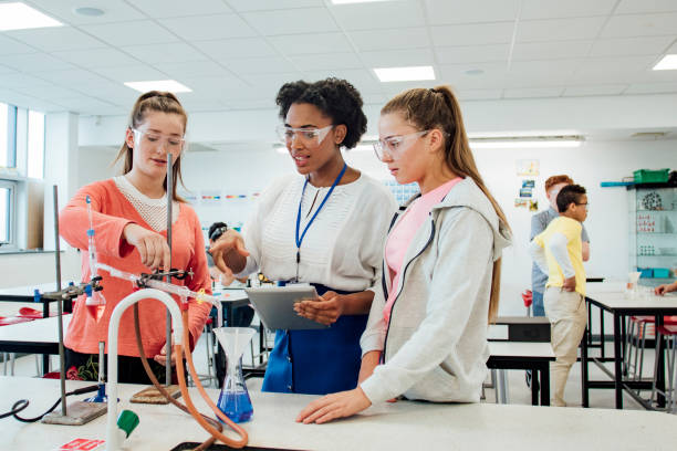 Teenage female students talking with the teacher about the experiment.