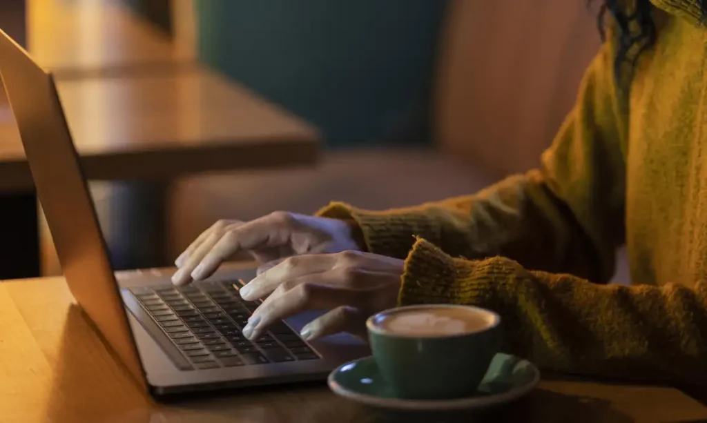 mulher-de-lado-trabalhando-em-seu-laptop-em-uma-cafeteria